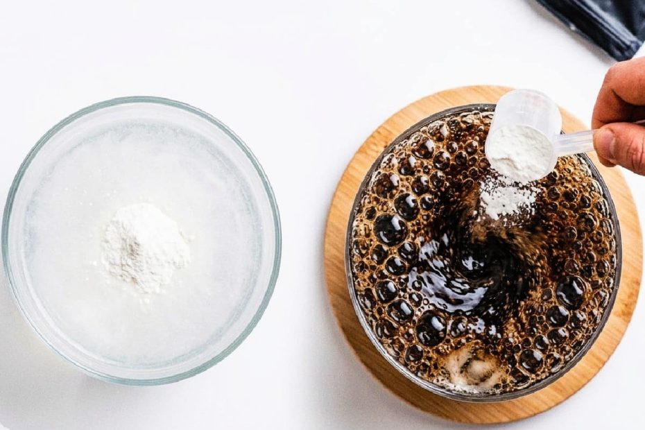 A minimalist top-down view on a white background. On the left, a glass with dark carbonated liquid receives creatine, generating chaotic bubbles. On the right, a glass with crystal clear water shows creatine settling stably. A hand holds a scoop over the carbonated drink.