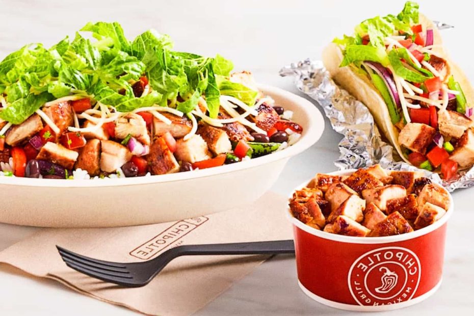 A Chipotle chicken burrito bowl with lettuce and beans next to a chicken taco and a side container of grilled chicken pieces.