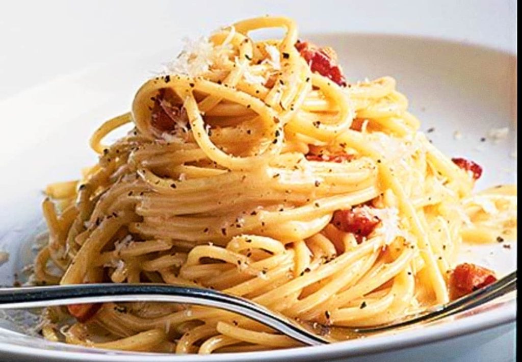 Creamy authentic carbonara recipe served on a plate with guanciale and black pepper