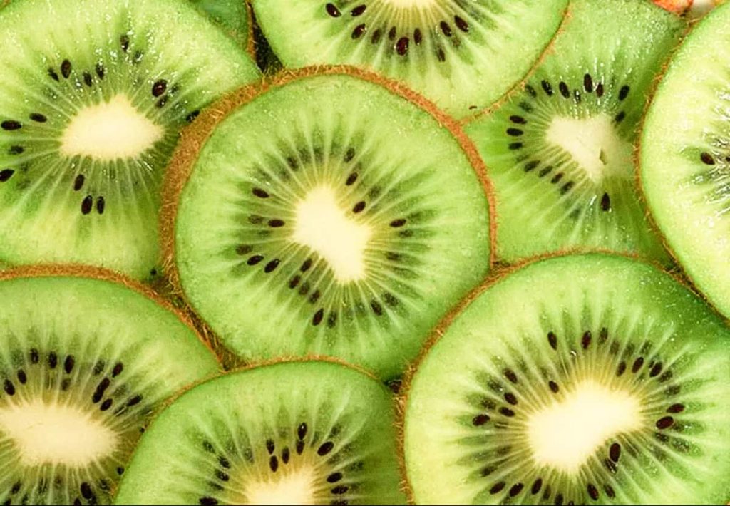 A photograph capturing kiwi health benefits by showing whole and sliced fresh kiwifruits, emphasizing natural nutrient density.