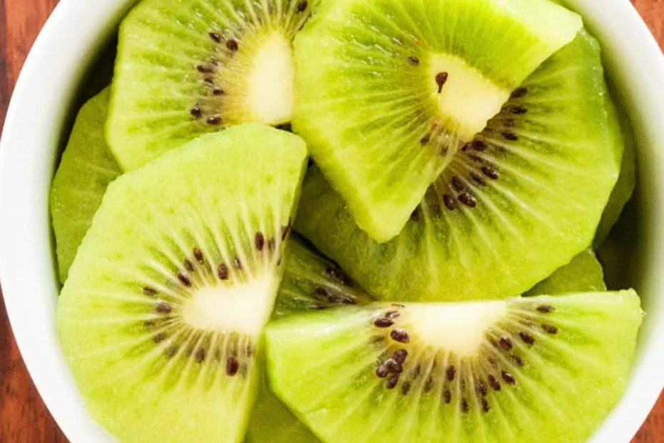 Fresh green kiwi slices served in a white bowl, representing the recommended daily intake for normal bowel function.