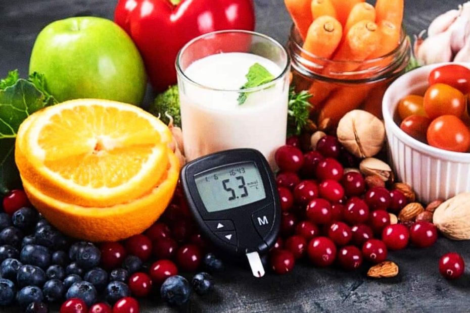 A blood glucose meter showing a reading of 5.3 surrounded by fresh fruits, vegetables, nuts, and a glass of milk.