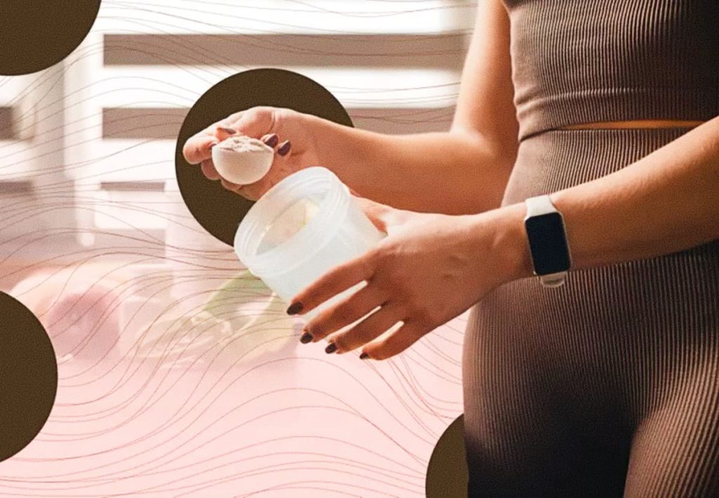 White plastic scoop filled with creatine powder sitting inside a supplement container.