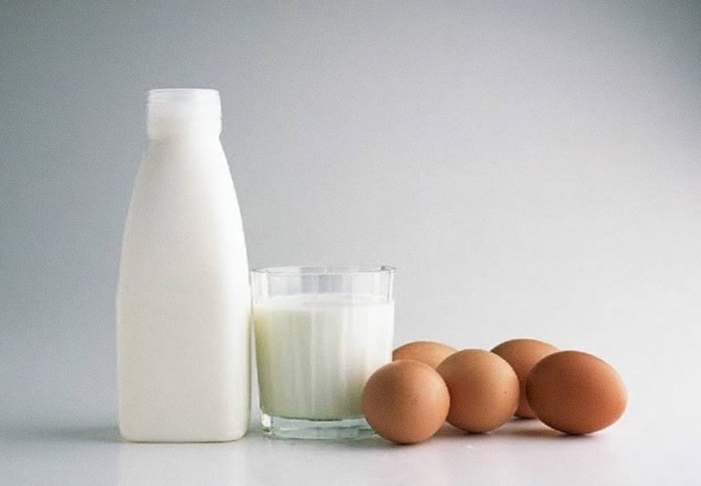 Pasteurized bottle of milk, glass, and eggs fulfilling safe functions of protein in the human body.